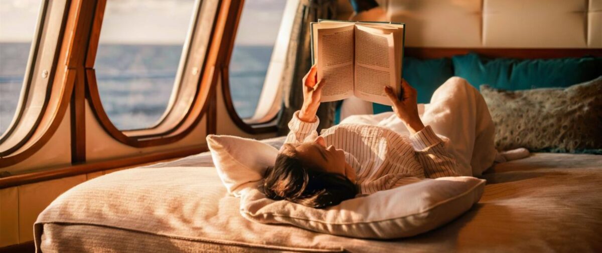 Lady reading a book insidea cabin on a cruise ship