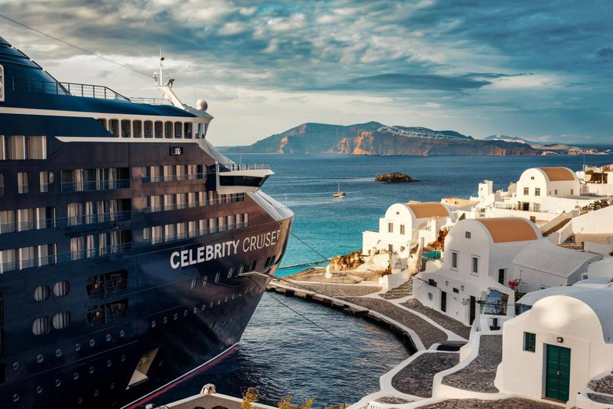 Cute town in Greece with white houses and cobblestones. With a Celebrity Cruise ship in the background