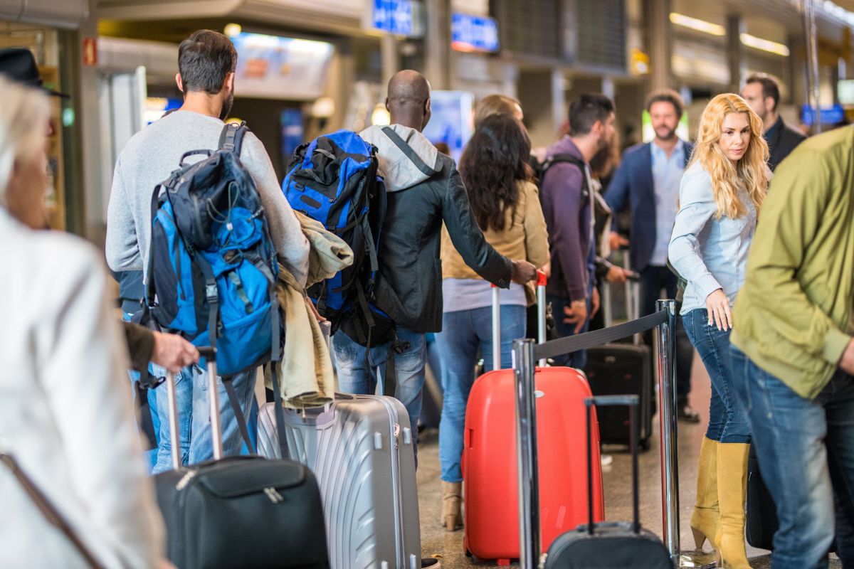 Busy UK airport with people waiting in que