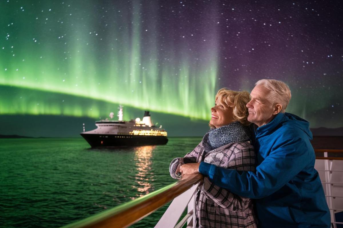 Older couple looking at the Northern lights from a cruise ship