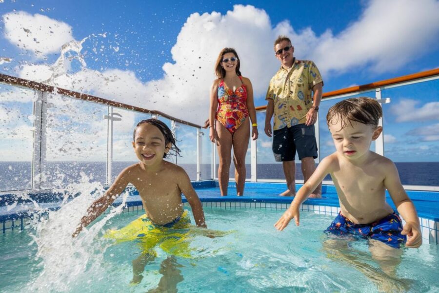 2 kids in a splash pool in the H2O zone supervised by parents on Allure of the Seas