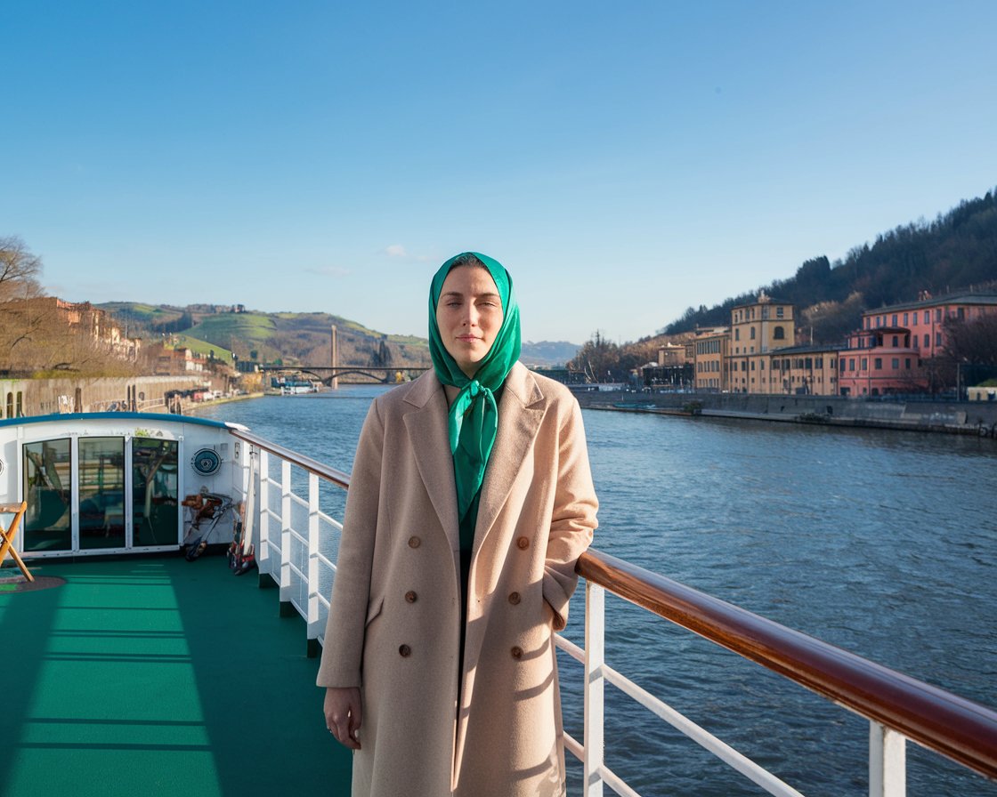 Person on a river cruise ship with Italy in the background