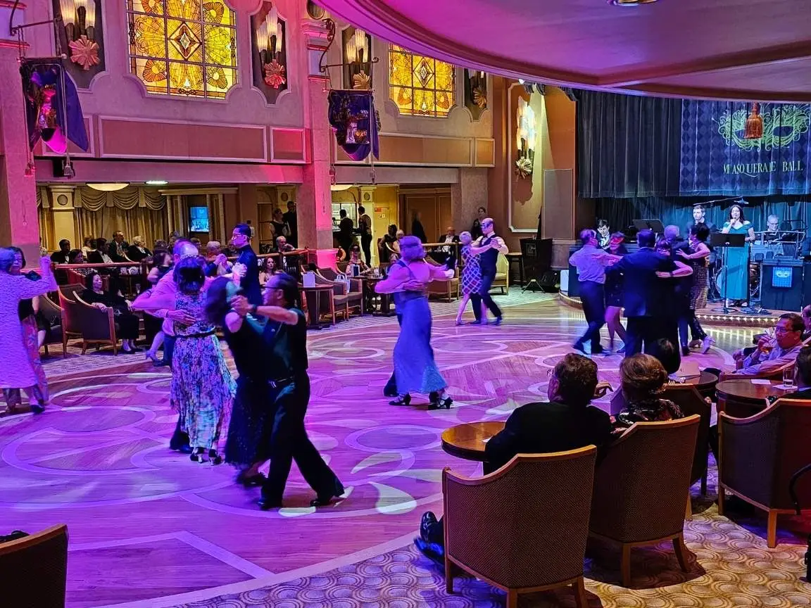 Masquerade ball at the Queens Room on Cunard Queen Elizabeth with passengers in formal wear dancing to live orchestra