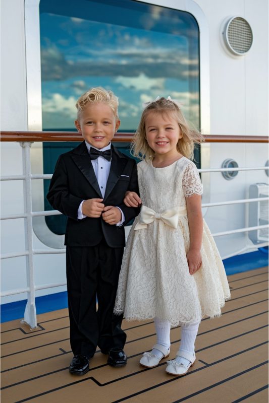 Cute boy and girl dressed in formal wear on a cruise