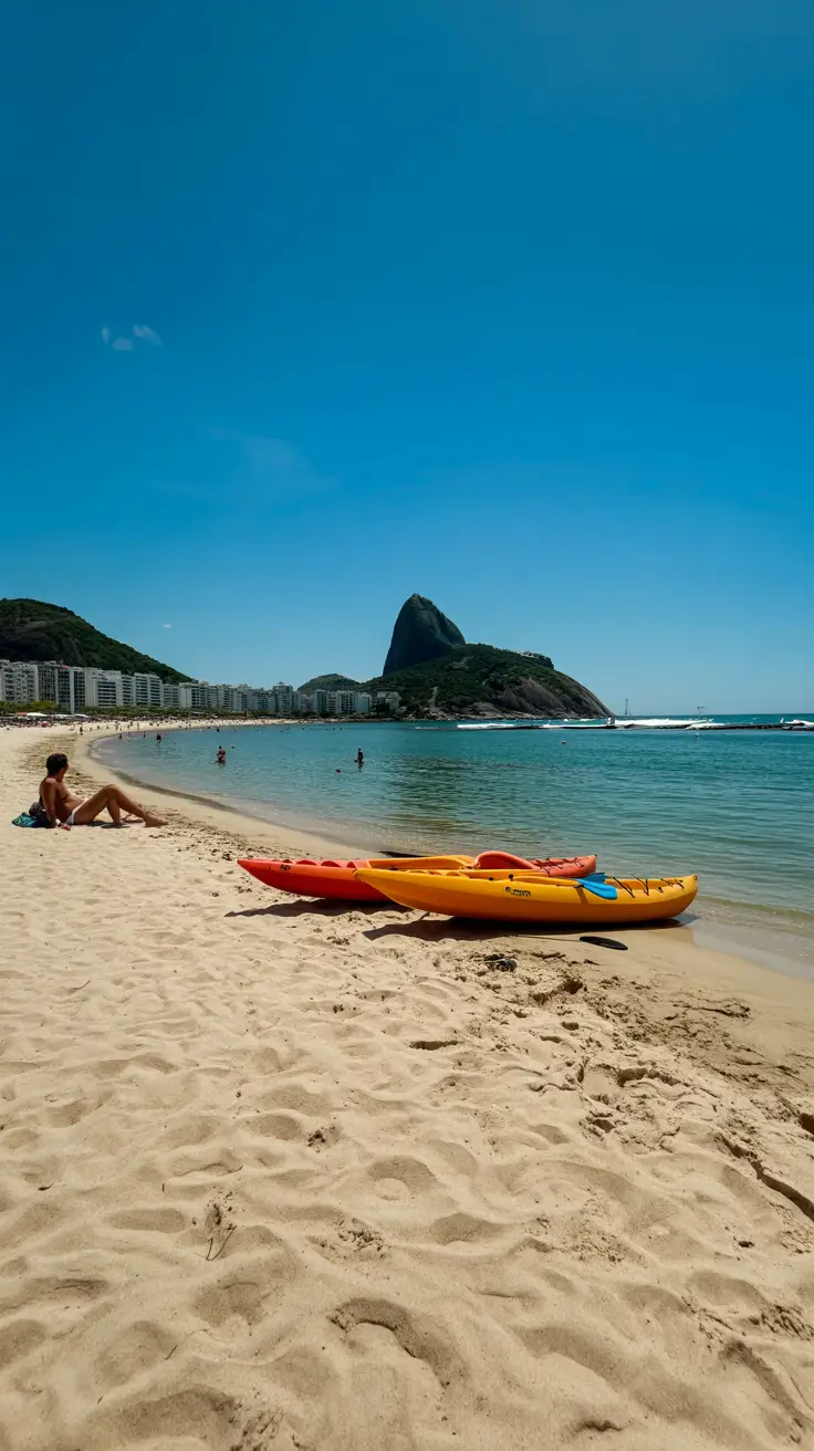 A bright, sunny day on Copacabana Beach with golden sand, clear blue water, colorful kayaks, and sunbathers near the shoreline.