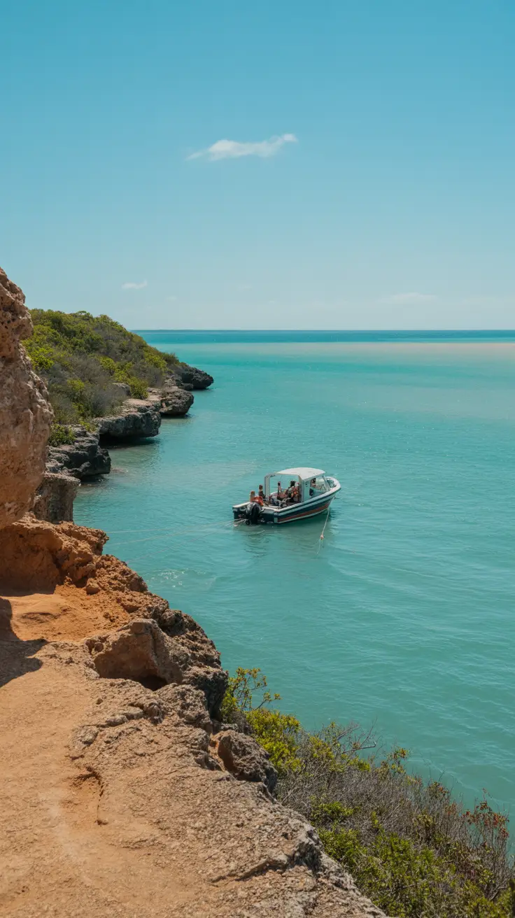 A bright, sunny day captures the clear turquoise waters of Cabo Rojo’s coast—on one side, a quiet cliffside trail in the national park, on the other, a small boat anchored near a guided tour group in the shimmering bay.