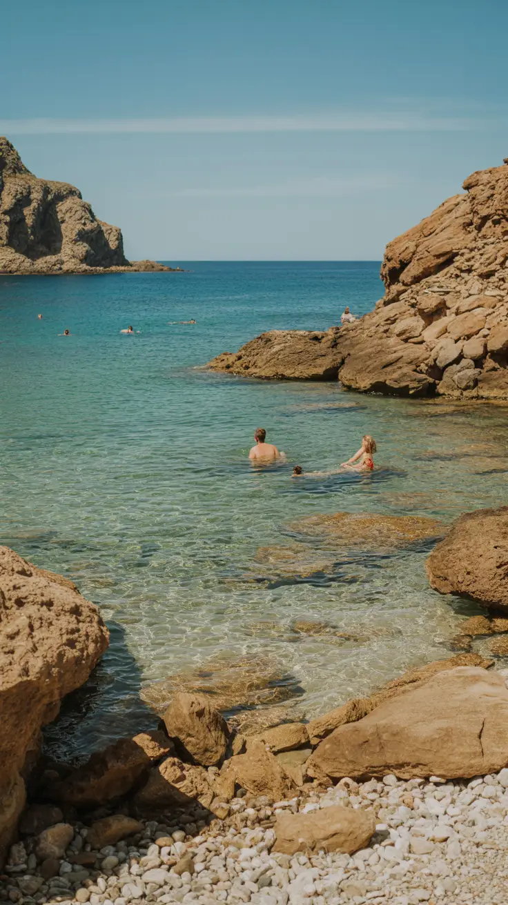 A quiet cove bathed in golden sunlight with clear turquoise waters gently lapping at sun-drenched rocks, completely deserted.