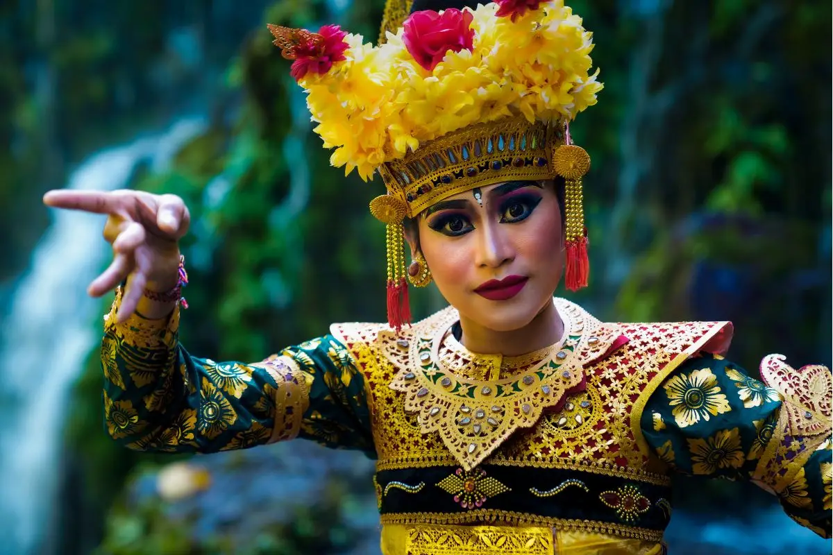Balinese dancer in traditional gold costume and ornate headdress performing cultural dance