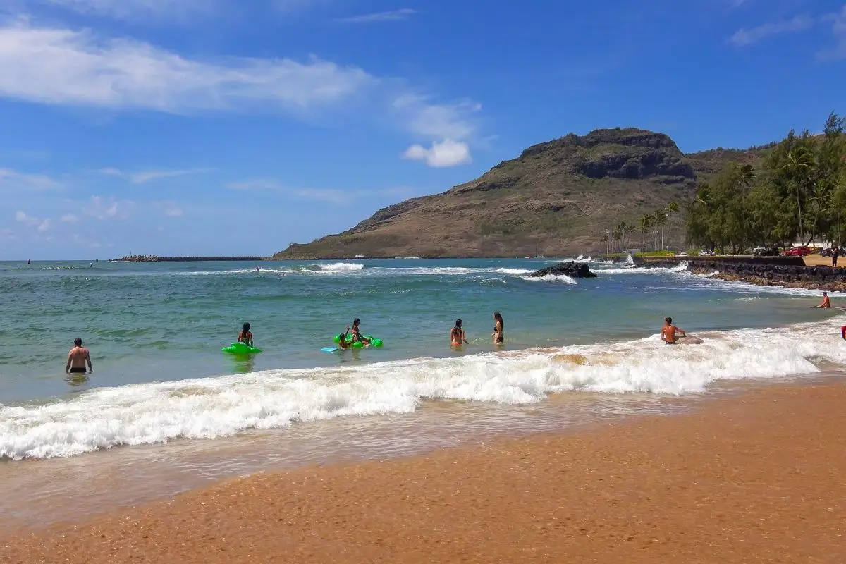 Kalapaki Beach Kauai with swimmers, golden sand, and mountain backdrop near cruise port
