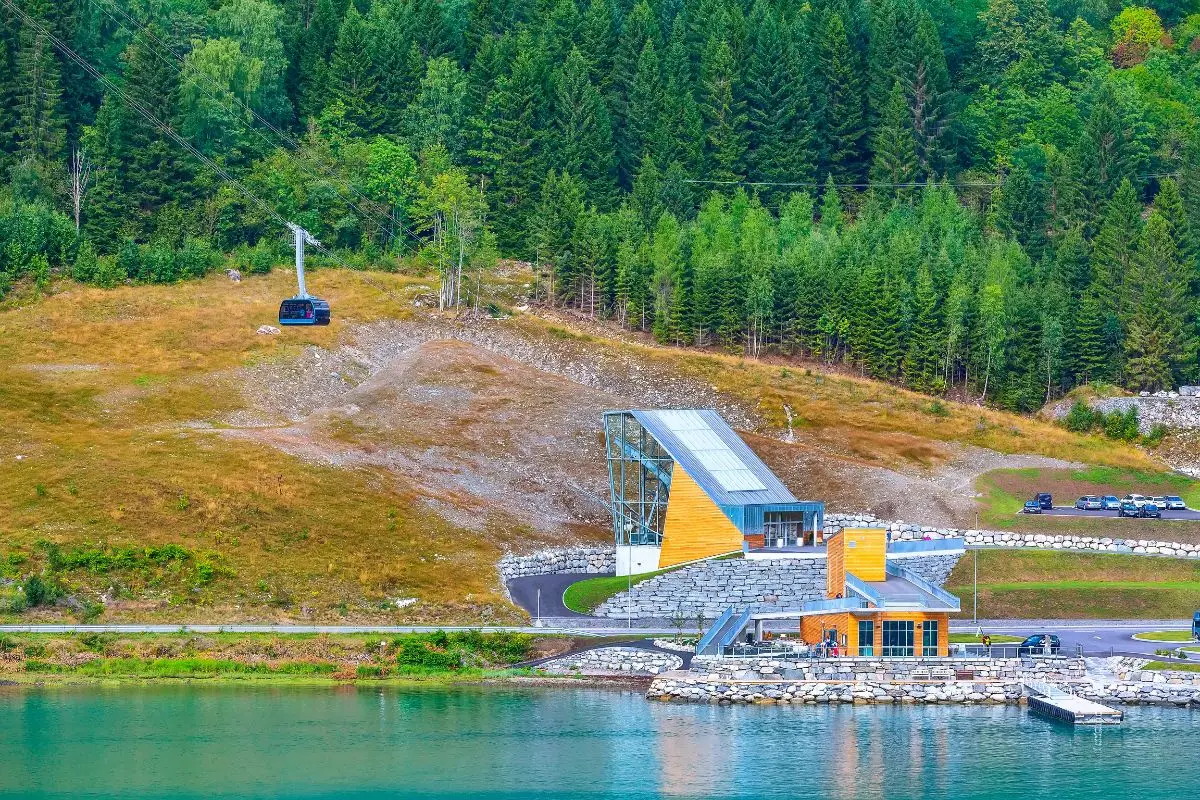 Loen Skylift cable car station with modern orange and blue building beside turquoise Nordfjord water near Olden Norway