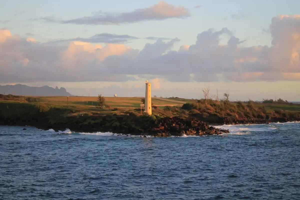 Ninini Point Lighthouse on rocky coast at sunset near Nawiliwili Harbor Kauai
