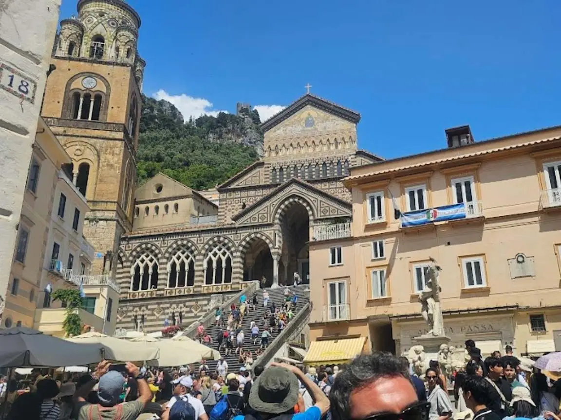 Amalfi Cathedral facade and Piazza del Duomo crowded with tourists at midday in late May