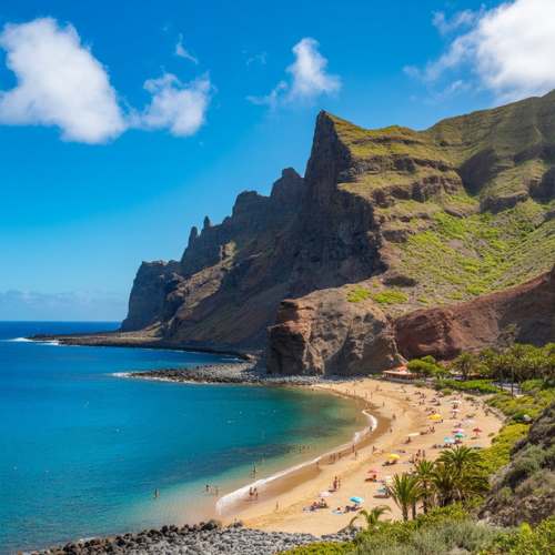 Tenerife beach with dramatic volcanic cliffs and clear blue Atlantic water, Canary Islands