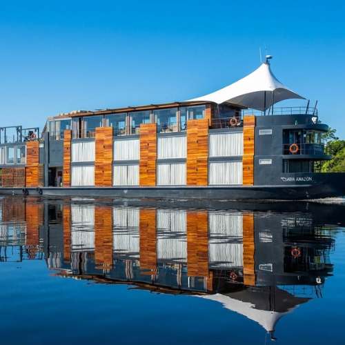 Boutique Amazon river cruise ship reflected in the calm waters of the rainforest