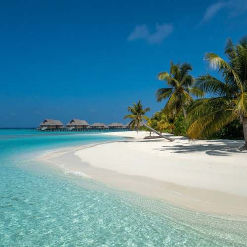 Maldives overwater bungalows on a white sand beach with crystal clear turquoise water