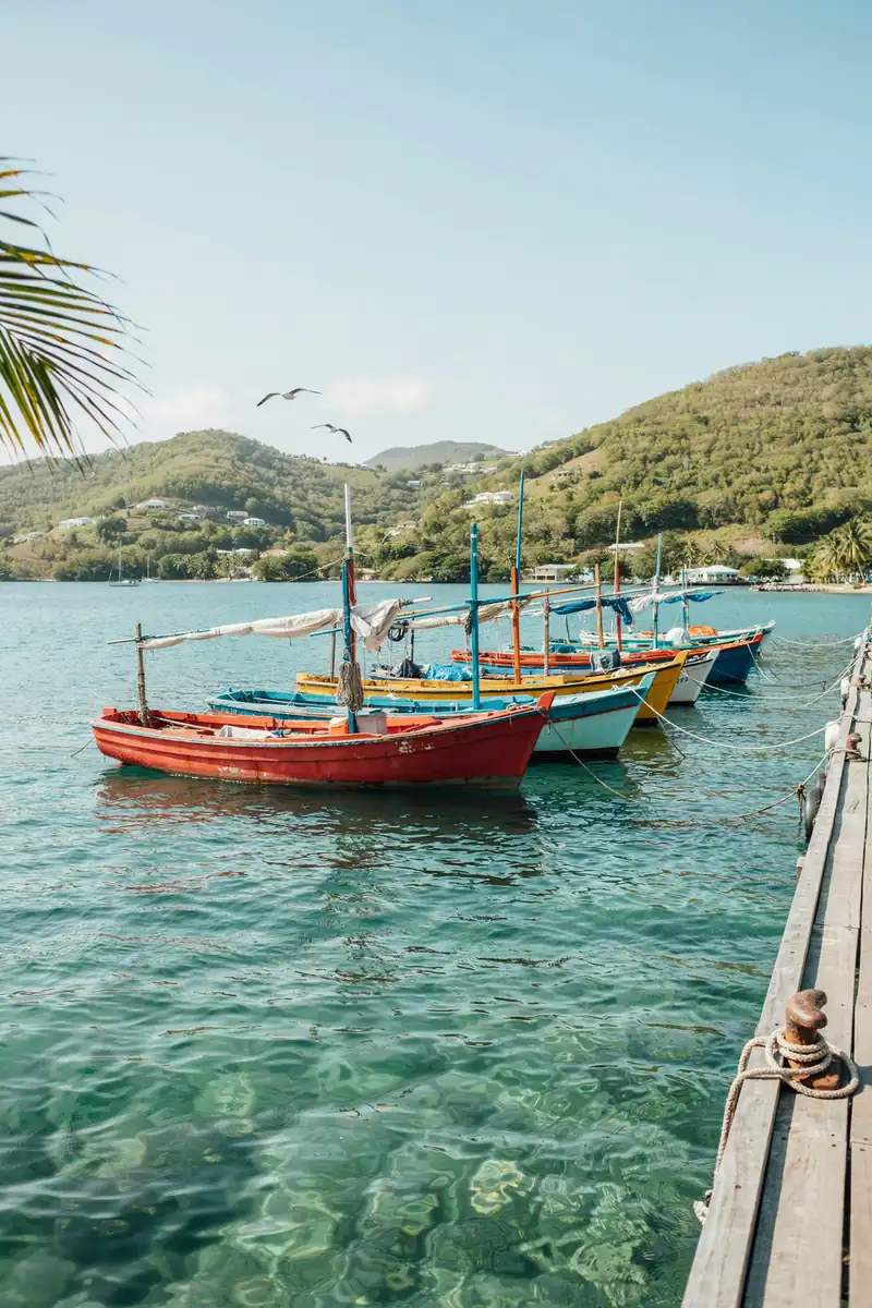 Harbour in Bequia with colourful fishing boats moored along the shore under a sunny sky