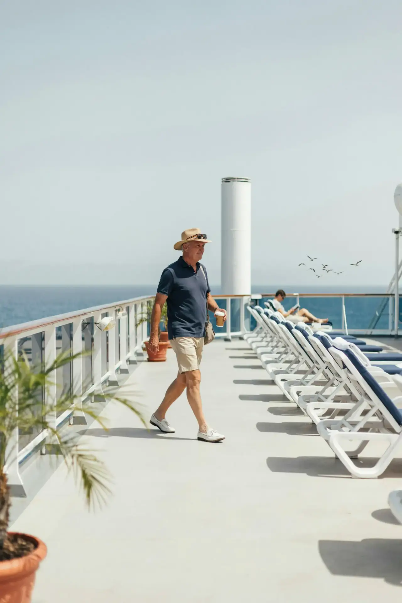 Sunlit deck area with sun loungers and a colourful water slide structure in the background