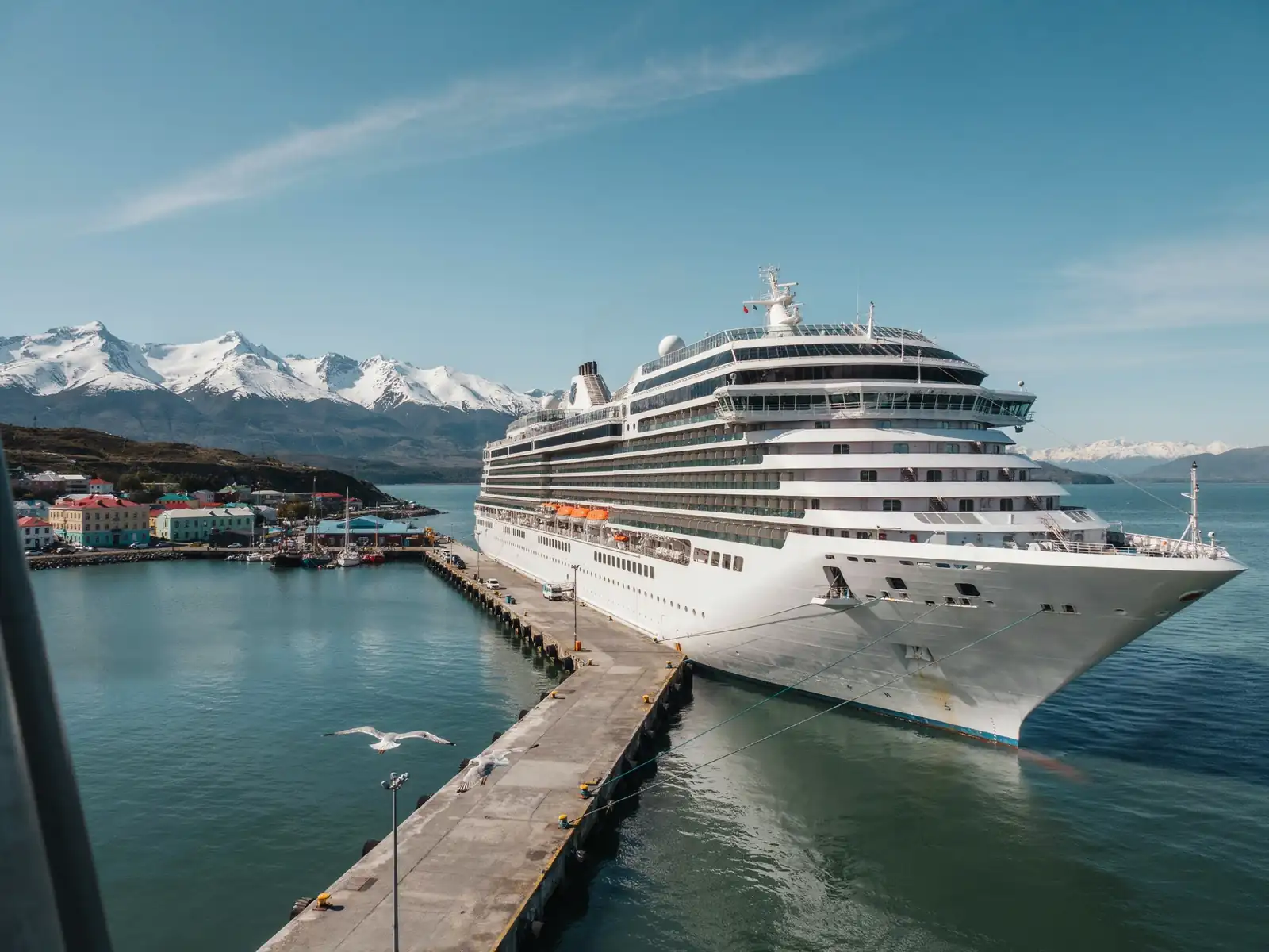 A cruise ship docked at the harbour in Ushuaia, Argentina, with mountains in the background