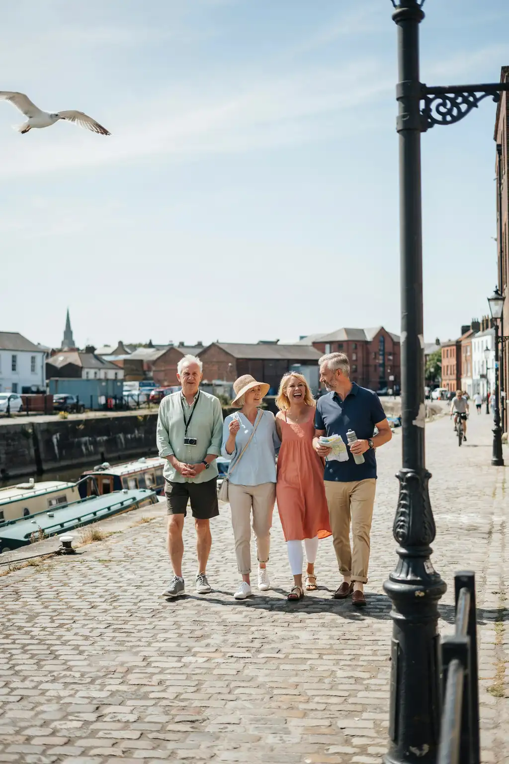 A sunlit street with older tourists walking together, casual clothing and comfortable footwear