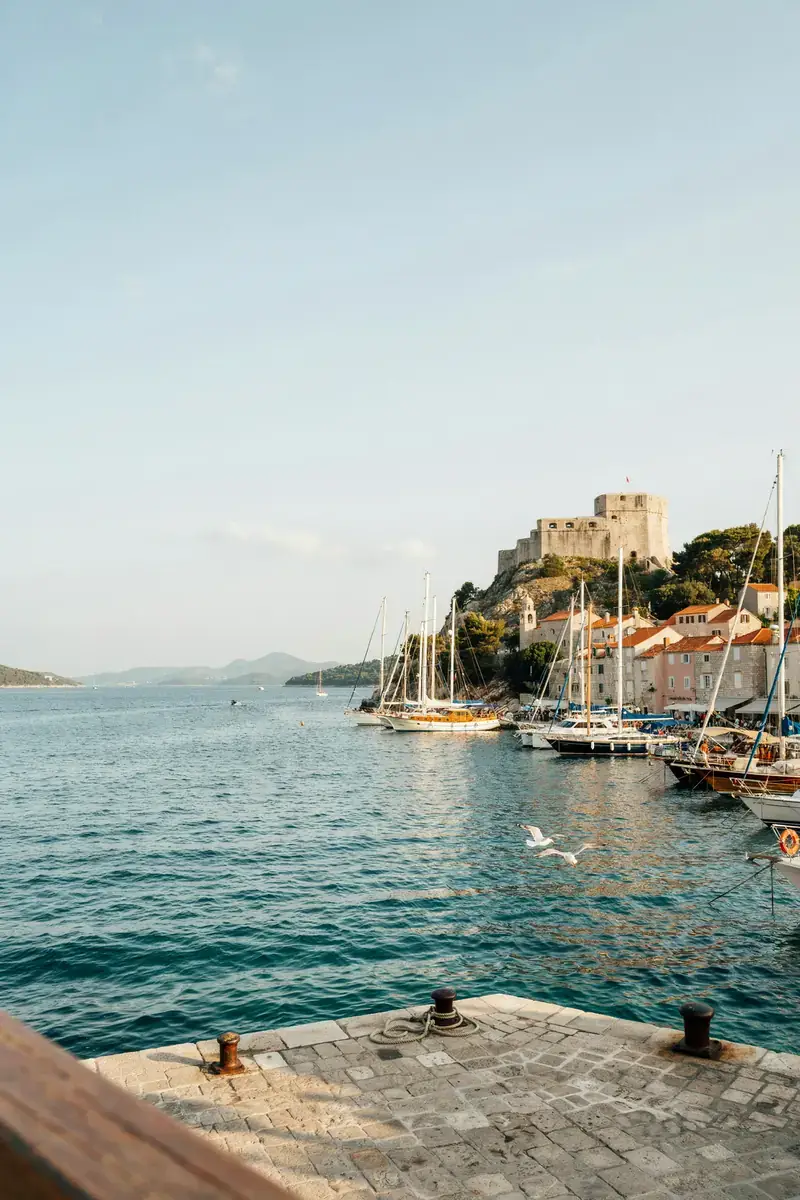 View of Hvar harbour with a hilltop stone fortress overlooking sailing boats in the bay