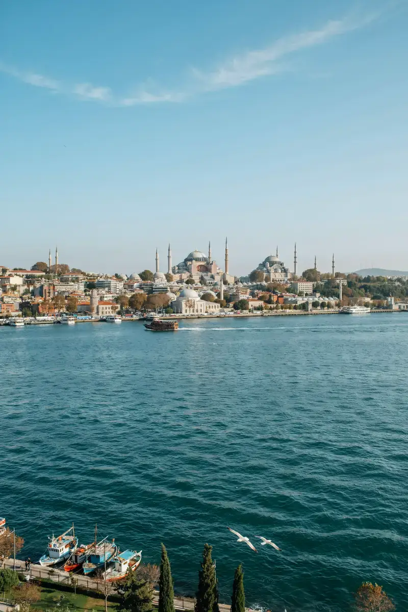Istanbul waterfront skyline with domed mosques and minarets along the Bosphorus on a sunny day