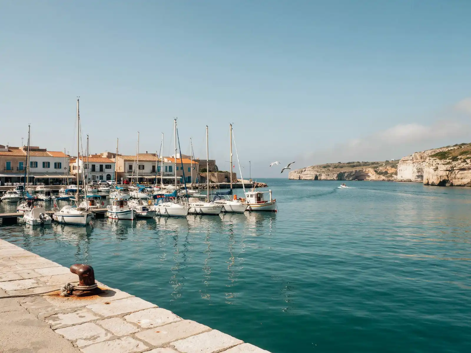 Harbour view of Mahon port in Menorca with boats docked along the quay