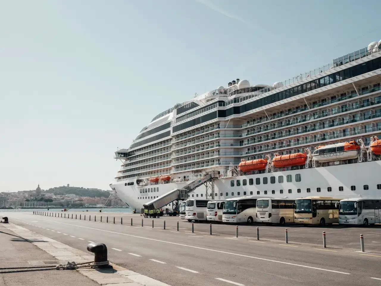 Cruise terminal at the port of Marseille with a docked ship and buses waiting nearby