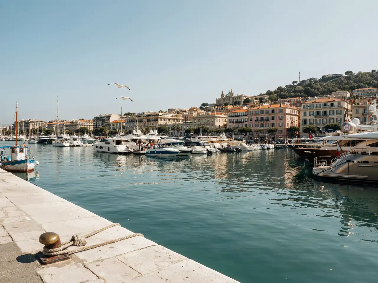 Monte Carlo harbour with moored yachts and cruise tenders on a sunny day