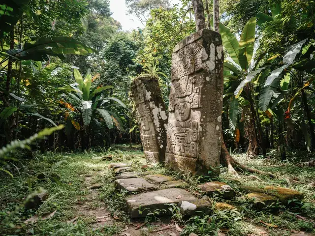 Ancient carved Mayan stone stelae surrounded by jungle at Quiriguá