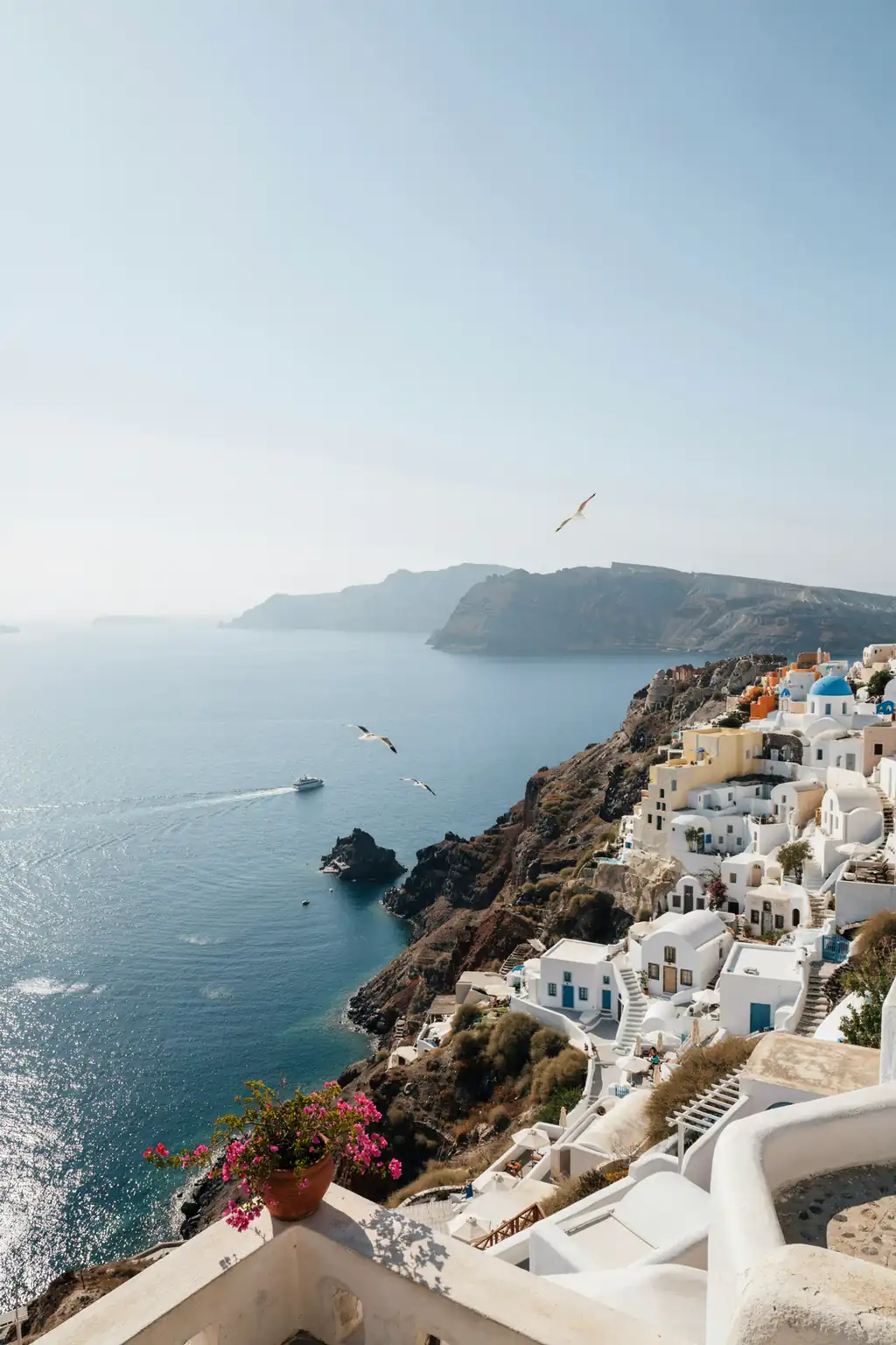 View of Santorini's caldera with whitewashed buildings perched on cliffs above the sea