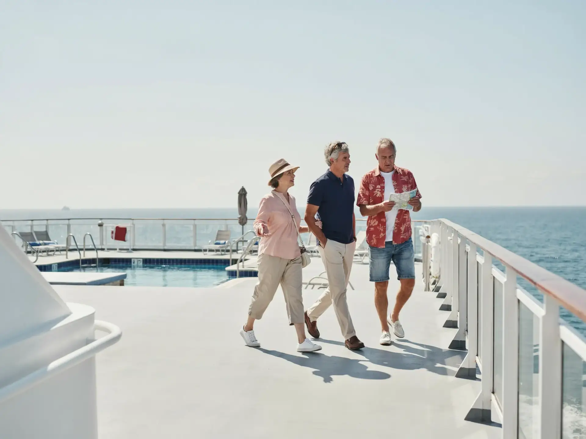 Older tourists strolling casually along a sunlit deck