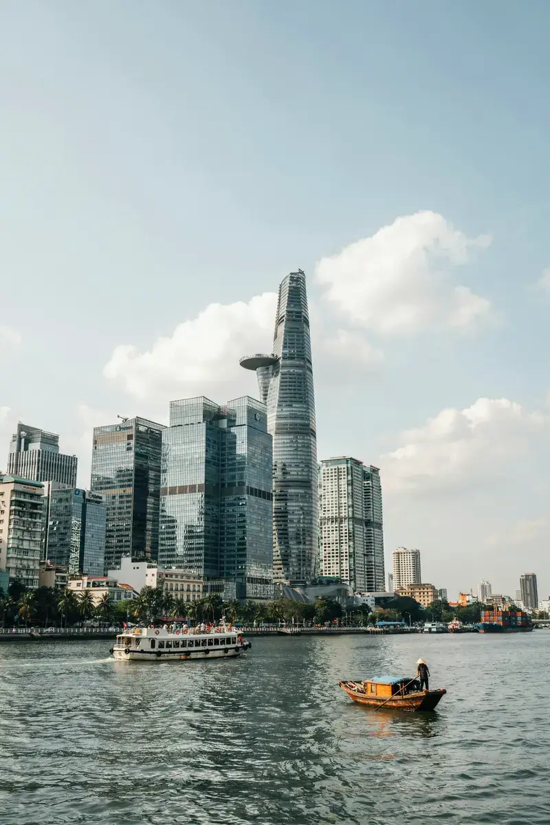 Skyline of Ho Chi Minh City with river and boats on a sunny day