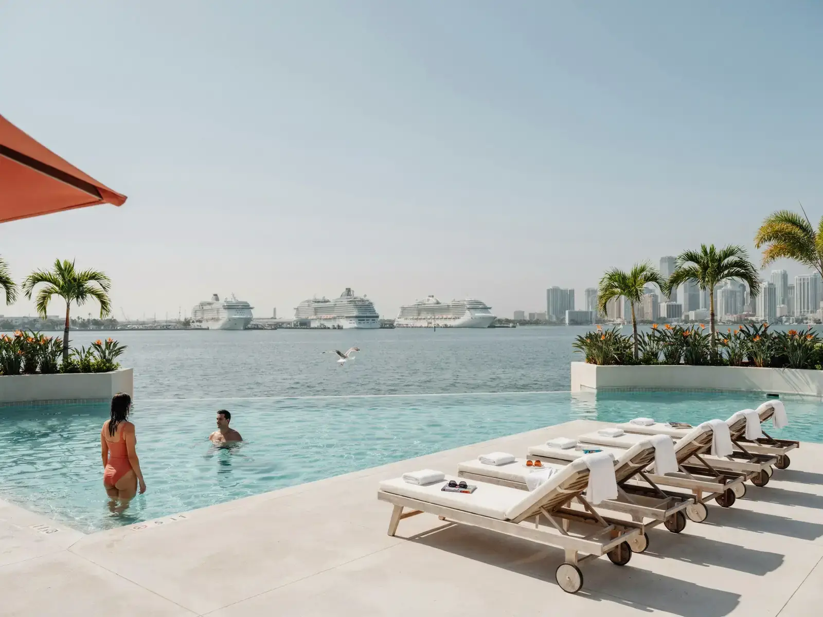 Outdoor hotel swimming pool with loungers near PortMiami harbour on a sunny day