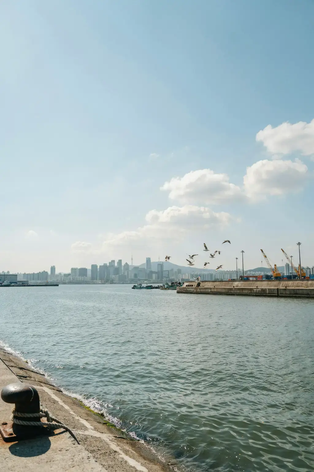 Incheon harbour with the Seoul skyline visible in the distance on a sunny day