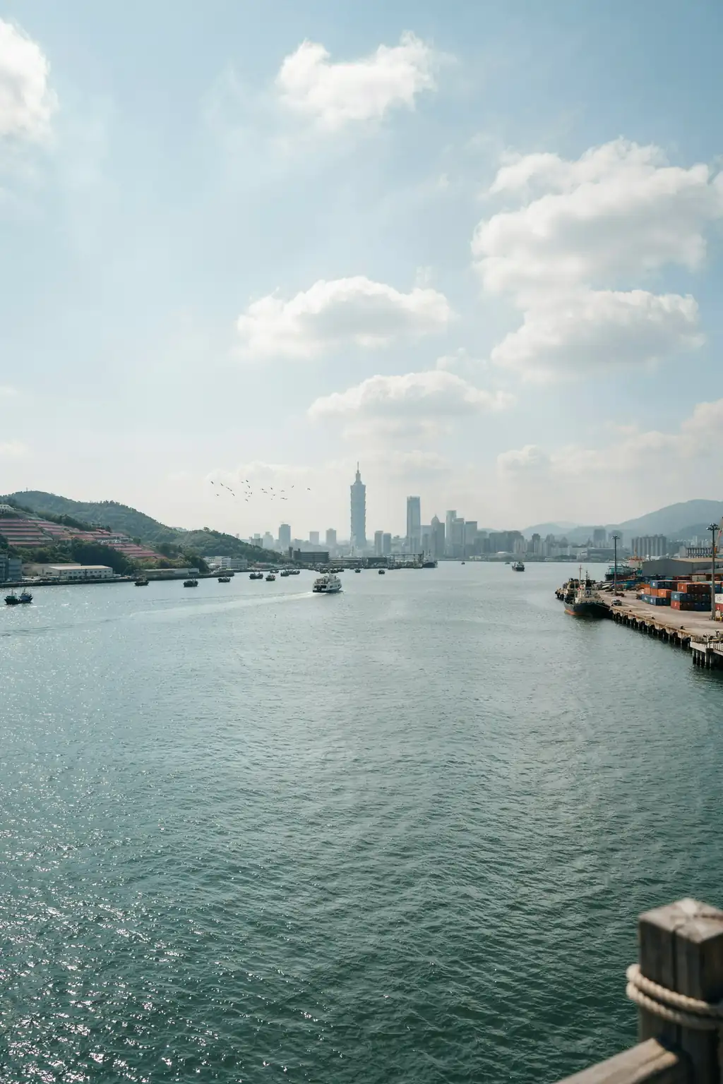 View of Keelung harbour with the Taipei skyline in the distance on a sunny day