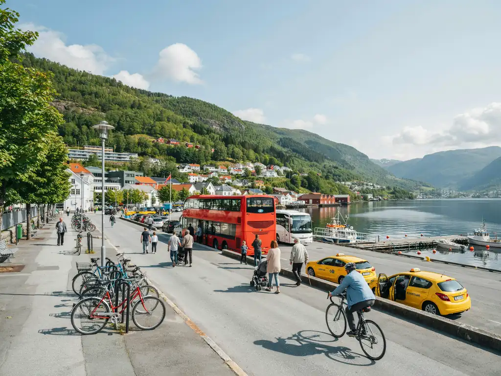 A Molde street scene showing a bus, taxi, and bicycles along the harbourside with fjord views in the background