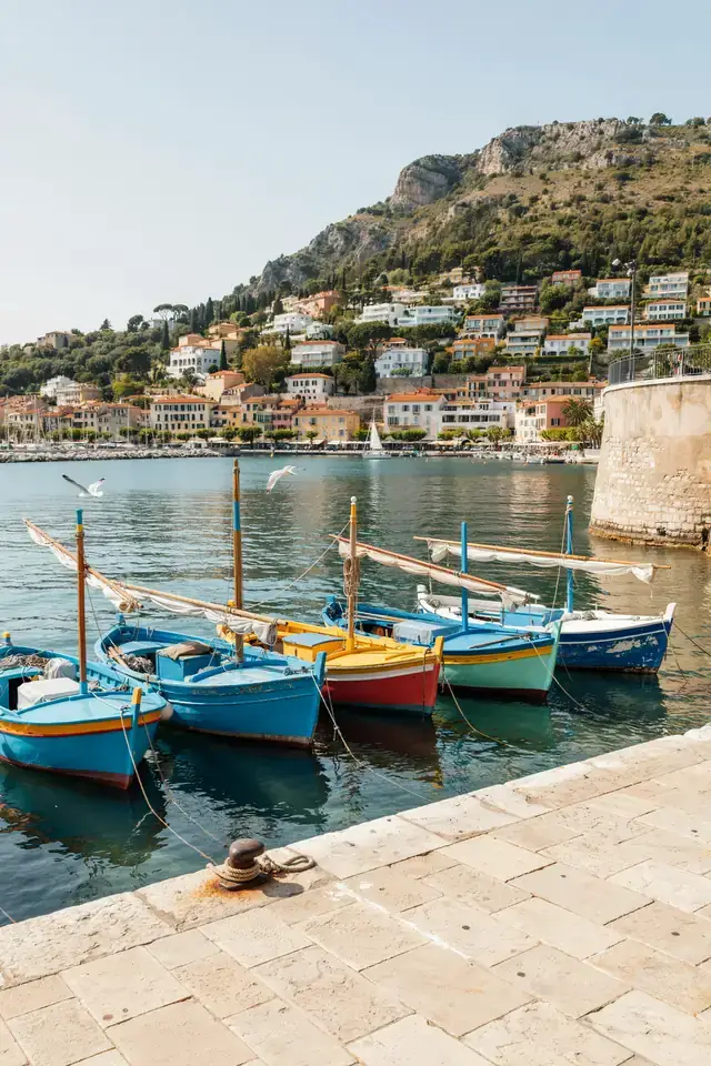 Sunny view of Nice harbour with colourful boats along the Riviera coastline