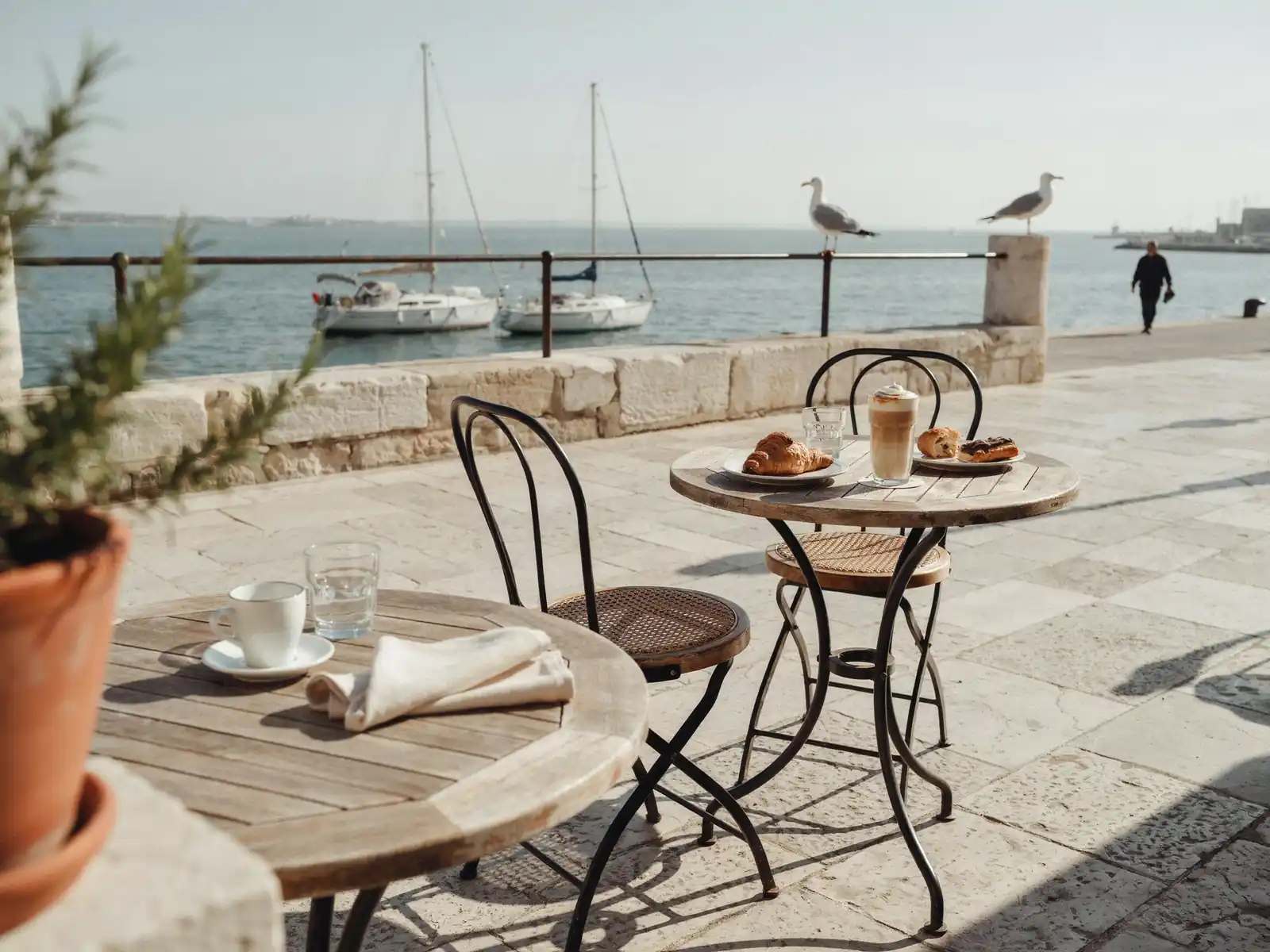 Portside cafe tables set with coffee cups and pastries