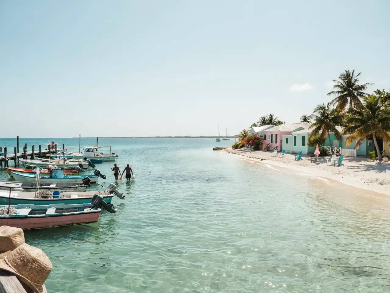 Bimini harbourside with turquoise water, docked boats and sandy beach under a sunny sky